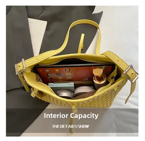 Detailed view of the large internal capacity in a yellow woven tote with daily items