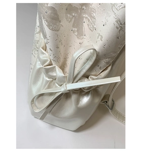 Detailed macro view of pearl leather and jacquard fabric with rhinestone accents and bow tied side