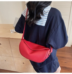 Model wearing a vintage red half-moon leather crossbody bag with lychee texture