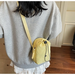 Détail du petit sac bandoulière en toile jaune étanche avec fermeture par cordon