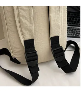 Close-up of adjustable black nylon straps and beige fabric on a minimalist backpack