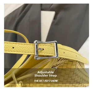 Detail of yellow woven bag with adjustable leather strap and silver metal buckle