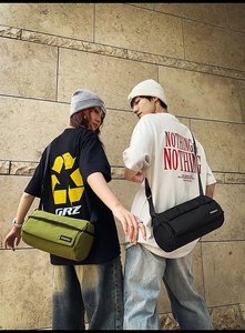 Présentation de deux sacs bandoulière cylindriques en nylon vert et noir avec logo