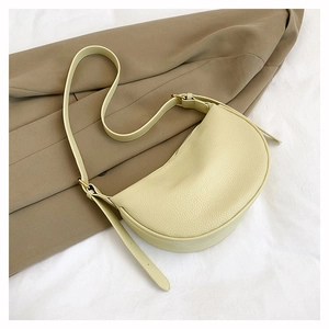 Details der Litschi-Maserung und Goldbeschläge an der beigen Halbmond-Tasche