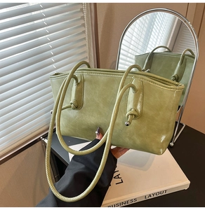 Détail du sac fourre-tout vert clair avec poignée nouée et perle métallique décorative