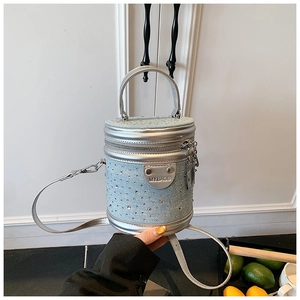 Détail macro du mini sac seau en denim avec strass étincelants et garnitures métalliques argent