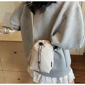 Petit sac bandoulière léger en nylon crème avec fermeture à cordon et sangle noire