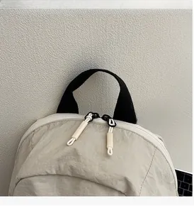 Detail of water-resistant nylon backpack featuring durable top handles and dual zippers