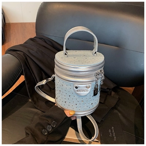 Détail du sac seau bleu clair avec strass argentés et plaque de logo MYBAGS en métal