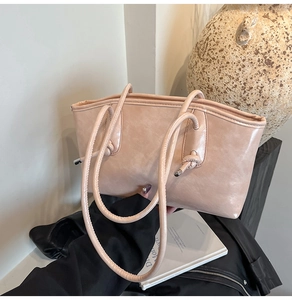 Détail du sac fourre-tout rose poudré en similicuir avec poignées cylindriques nouées