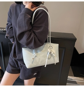 Borsa tote verde chiaro in pelle con fiocco crema e catena di perle decorativa