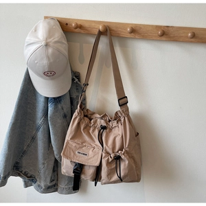 Khaki Umhängetasche aus Nylon mit Kordelzug und Schnallentasche an einem Kleiderhaken