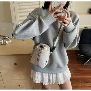 Détail du petit sac bandoulière beige en toile imperméable avec cordon de serrage