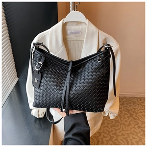 Detail of black woven texture shoulder bag with silver M pendant and zipper closure