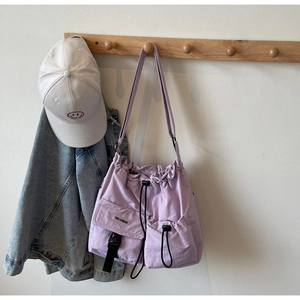 Detail der hellvioletten Nylon-Umhängetasche mit Kordelzug und Schnallentaschen