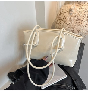 Détail du sac cabas crème avec anses en corde et embouts métalliques argentés, style moderne