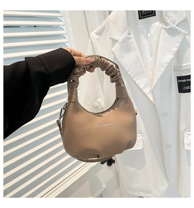 Détail du sac à bandoulière en cuir kaki avec une poignée froncée au design unique
