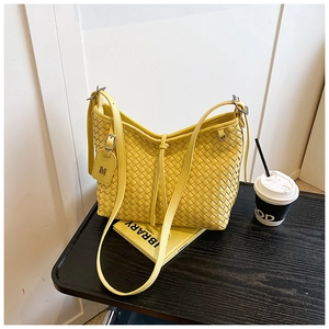 Close-up of bright yellow woven leather hobo bag with M charm and dense texture