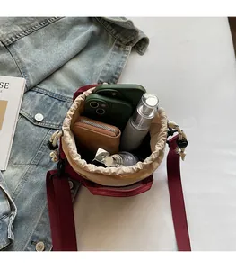 Internal view of red drawstring bucket bag showing storage for phones and wallet