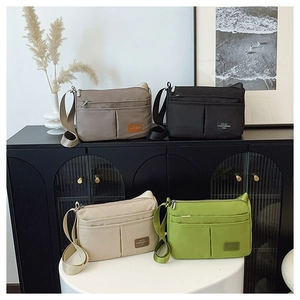 Detail showing high-capacity nylon crossbody bags in four colors with adjustable straps