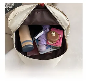 Top view of white leather backpack interior showing large capacity for umbrella and tablet
