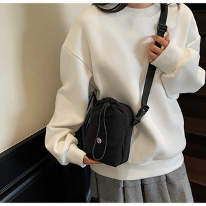 Détail de la petite sacoche téléphone en nylon noir avec cordon et bandoulière réglable