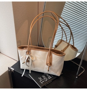 Dettagli di un'elegante borsa tote marmorizzata con manici marroni e nastro decorativo
