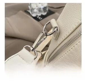 Close-up of cream white backpack with lychee grain texture and silver metal hook