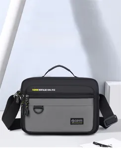 Detail view of Oxford fabric messenger bag featuring grey panels and contrast zipper pulls