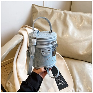 Détail du sac seau bleu clair avec strass étincelants et finitions argentées