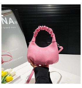 Pink crescent handbag with lychee pattern leather and ruched handle detail close-up
