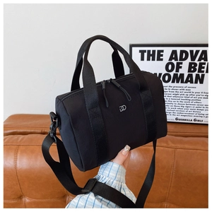 Détail du sac polochon noir avec doubles poignées et logo métallique LD élégant