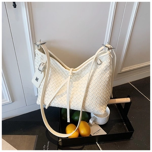 Detailed close-up of cream woven shoulder bag with silver hardware and M charm