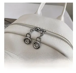 Detail of premium white lychee leather backpack with smooth dual metal zippers