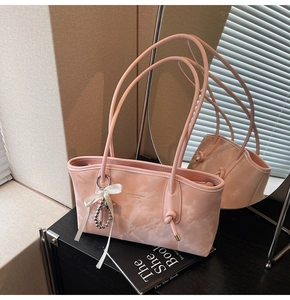 Elegante borsa sottobraccio rosa marmorizzata con fiocco bianco e ciondolo a perla