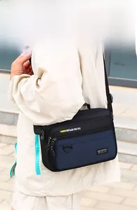 Detail view of multi-pocket oxford crossbody bag with waterproof fabric and zippers