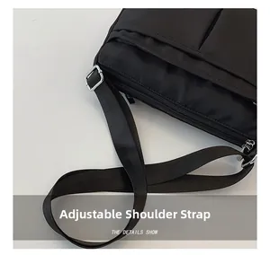 Detail of adjustable woven strap and silver metal buckle on a black nylon crossbody bag