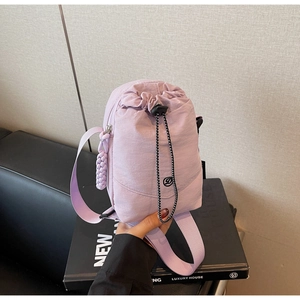 Détail du sac à cordon en nylon violet clair montrant la texture et le logo D noir