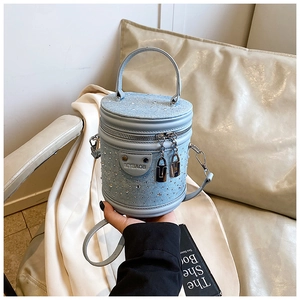 Vue détaillée du sac seau en denim bleu clair orné de strass brillants et fermeture éclair