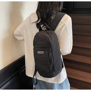 Close-up of black nylon backpack on a person walking on stairs in a warm setting