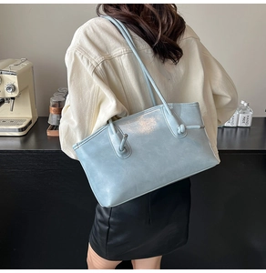 Détail d'un grand sac cabas bleu clair montrant le nœud de la sangle et le cuir souple