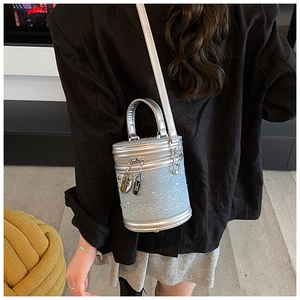 Détail du sac seau bleu clair avec strass et lanières en cuir argenté brillant
