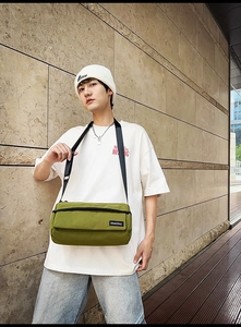 Détail du sac polochon en toile vert olive avec sangle réglable et logo