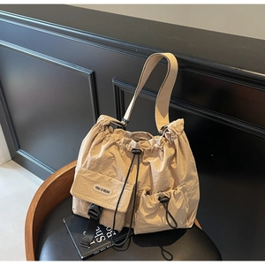Detailansicht der beigefarbenen Nylon-Umhängetasche mit Multi-Taschen-Design und Kordelzug
