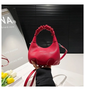 Close-up of red hobo bag with lychee texture, ruched handle, and FASHION & BAGS logo