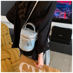 Vue détaillée du sac seau bleu clair avec clous brillants et bandoulière en chaîne argent