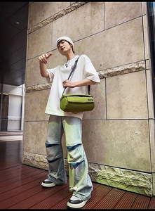Photo street style d'un sac bandoulière cylindrique vert herbe avec sangle réglable