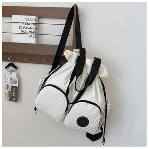 Close-up of cream drawstring backpack with crinkled nylon fabric and zip front pockets
