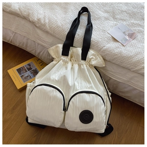 Close-up of ivory drawstring backpack with double front zippers and nylon straps