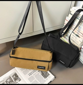 Détails des sacs cylindriques en nylon kaki et noir avec des bandoulières réglables